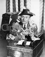 Man sitting in a trunk with money in his hands