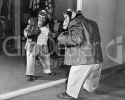 Chimpanzee in a jacket and trousers in front of a mirror