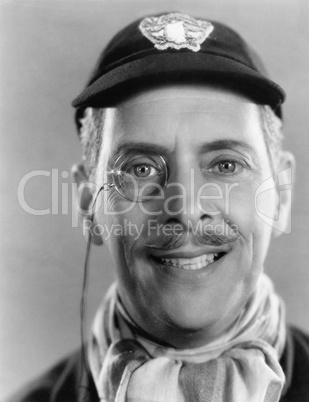 Man laughing and a monocle and a cap in his head