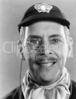 Man laughing and a monocle and a cap in his head