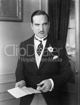 Man in a morning suit pointing at a piece of paper