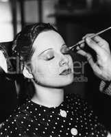 Young woman having make up done