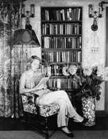 Young woman reading in her library