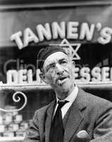 Jewish man standing in front of a storefront