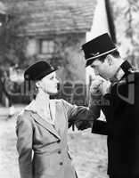 Man in an uniform kissing the hand of a young woman