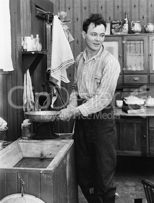 Man in a kitchen pumping water
