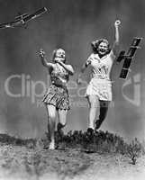 Two women running and playing with model airplanes