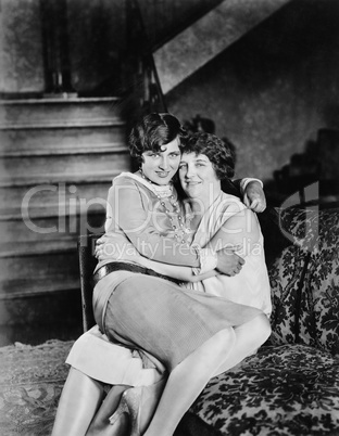 Two women sitting together on the other's lap