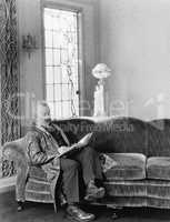 Man sitting on sofa and reading a book