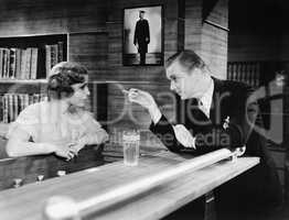 Man and woman standing together at a bar counter and talking