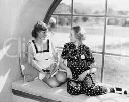 Two women in front of a window looking at each other