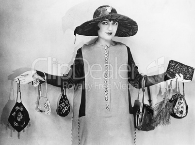 Woman standing with her arms apart wearing handbags