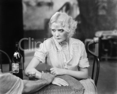 Woman sitting with a person in a restaurant looking upset
