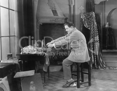 Man in his studio putting on shoes