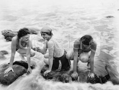 Three women playing in water on the beach