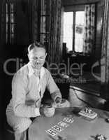 Man sitting in his living room playing cards
