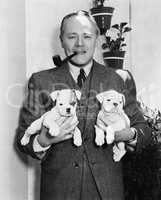 Man holding two English Bulldog puppies