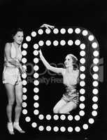 Two young women posing with the letter O