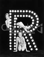 Two young women posing with the letter R