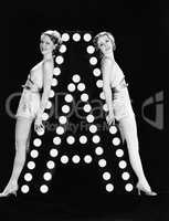 Two young women posing with the letter A
