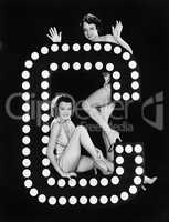 Two young women posing with the letter C