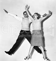 Couple jumping with their arms outstretched
