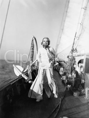 Young woman standing on a deck of a sailboat and smiling