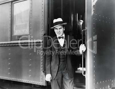 Young man standing at the entrance of a train