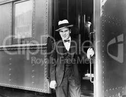 Young man standing at the entrance of a train