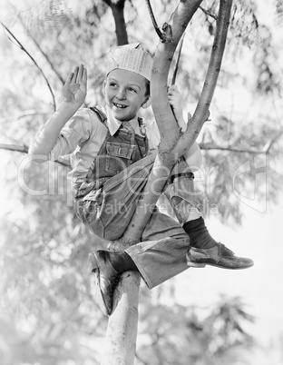 Low angle view of a boy sitting on a tree