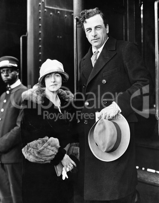 Couple standing at a railroad station platform