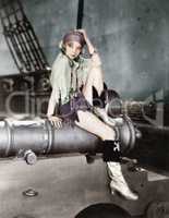 Profile of a young woman sitting on a cannon and thinking