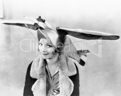 Portrait of a young woman wearing an airplane shaped cap