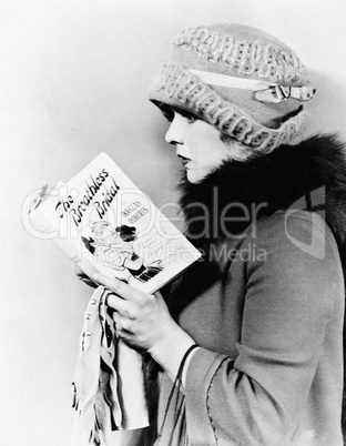 Profile of a young woman reading a book