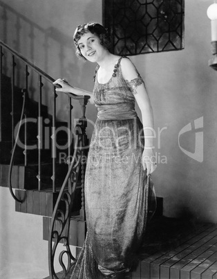 Young woman moving down a staircase and smiling