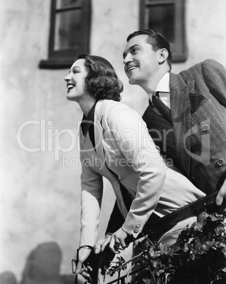 Couple standing at a balcony and smiling