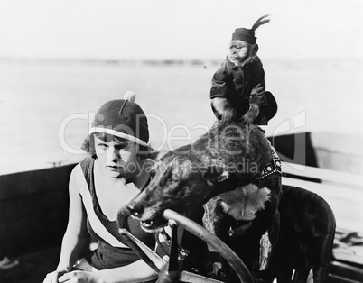 Teenage girl sitting in a motorboat driven by a dog