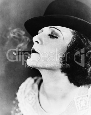 Portrait of a young woman with a hat smoking a cigar