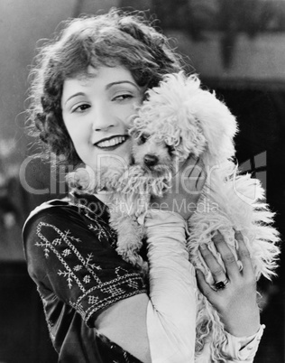 Young woman playing with her dog and smiling