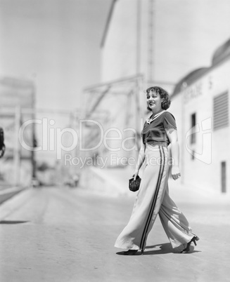 Young woman walking across the road