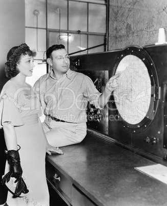 Man explaining about radar to a young woman in a control room