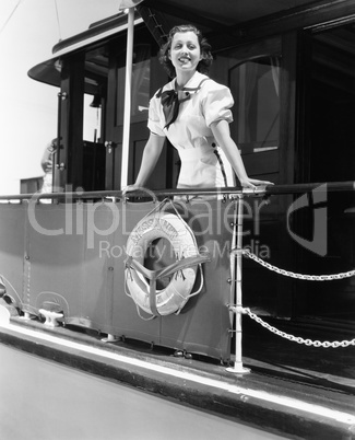 Young woman standing at the railing of a boat and smiling