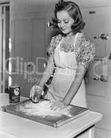 Young woman pouring water into flour
