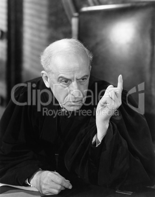 Judge in a courtroom pointing his finger up