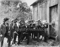 Group of men with guns and top hats breaking into a barn