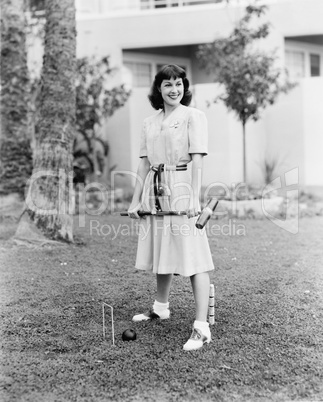 Woman playing croquet in the yard
