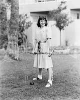 Woman playing croquet in the yard