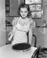 Portrait of a young woman preparing a blueberry pie in the kitchen