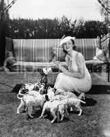 Woman feeding her dog and puppies