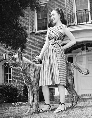 Young woman standing with her Great Dane in a courtyard